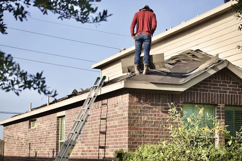 Professional roofer working on a residential roof in Halfway